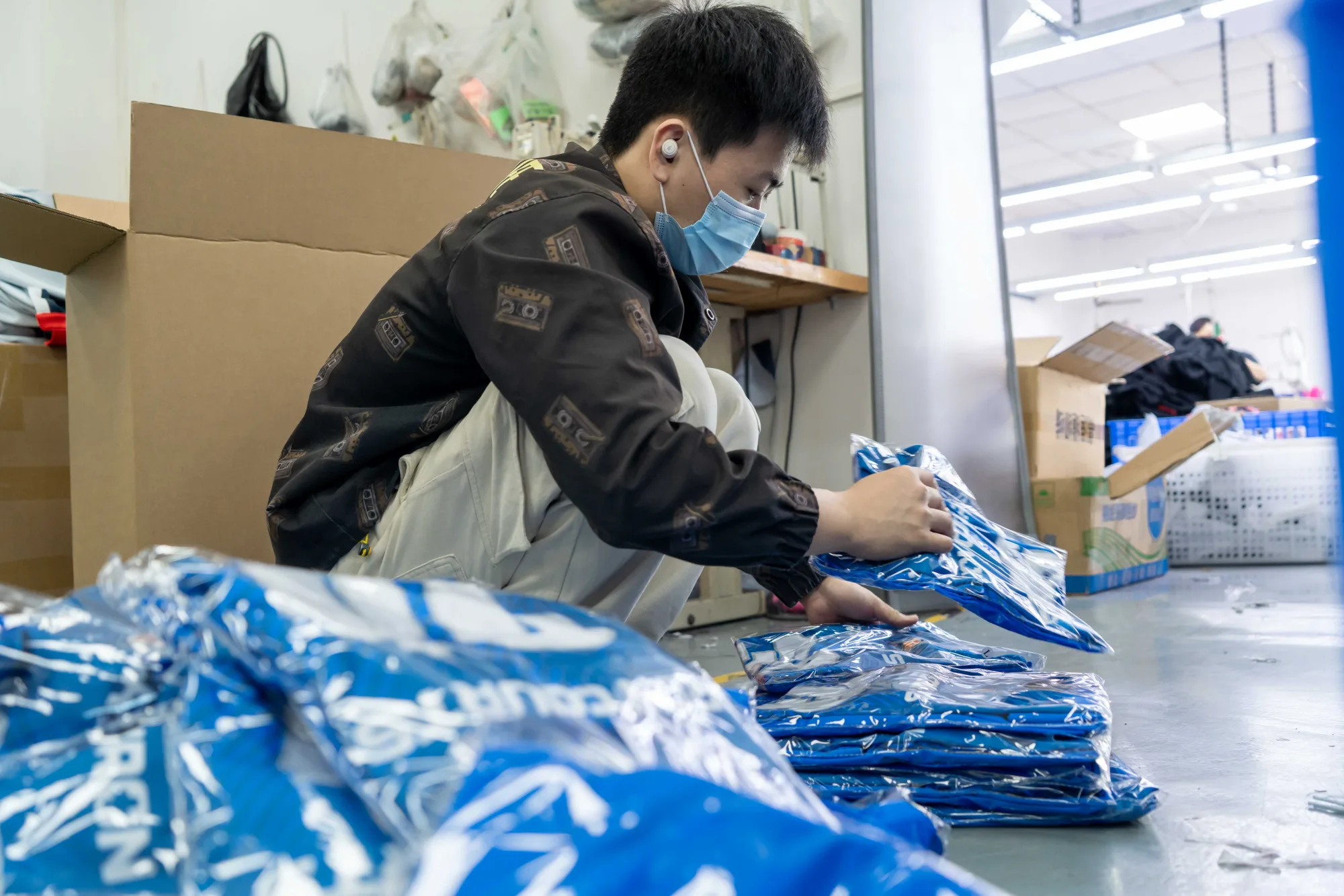 Garments being prepared for packing in a bulk custom sportswear order